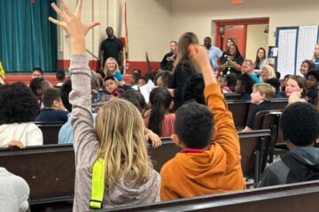 Spring Park Elementary students raise their hands during the "JA in a Day" assembly.