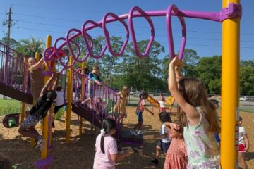 Ruth N. Upson students play on the monkey bars of the new playground
