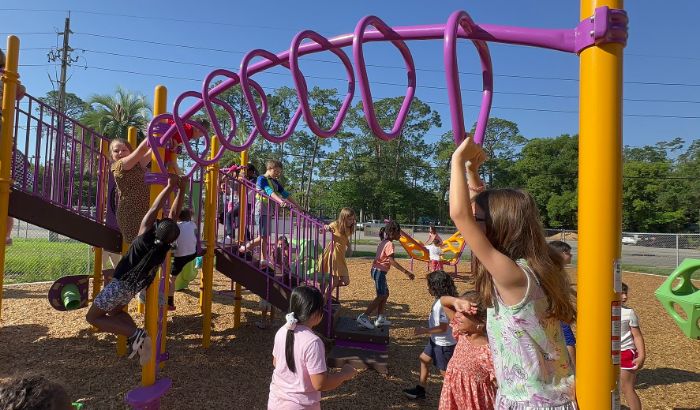 Ruth N. Upson students play on the monkey bars of the new playground