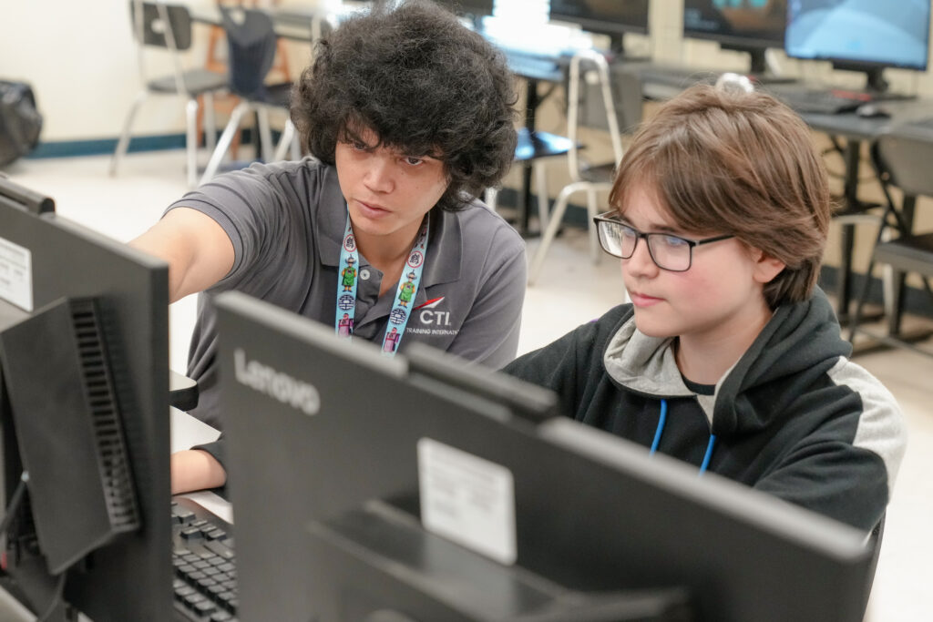 Duval county middle school student and teacher work at a computer