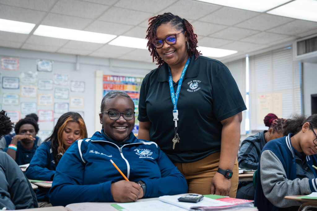 Ribault middle school student and teacher smiling at desk