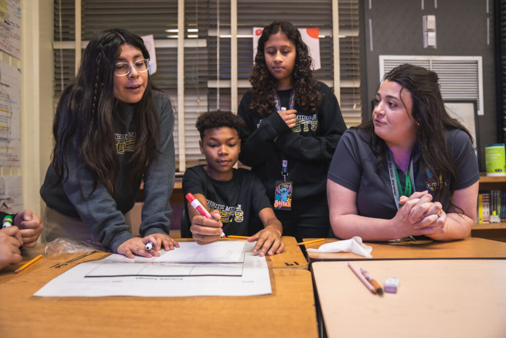 duval middle school students work with teacher on an assignment 